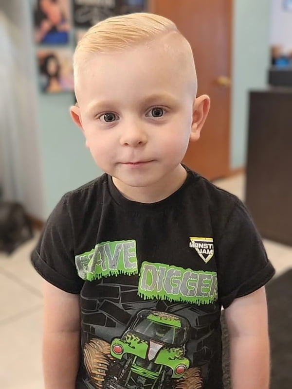 young blonde boy in grave digger tshirt after haircut