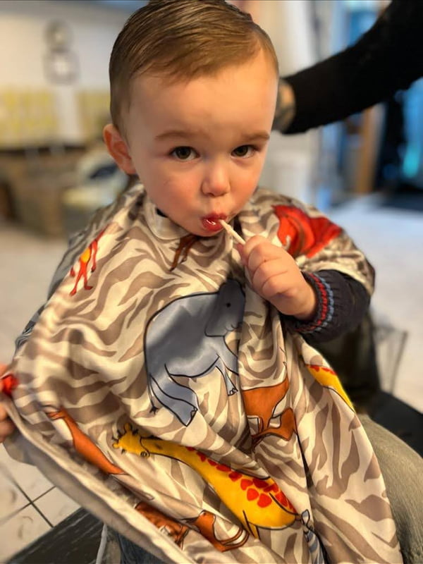 young boy with a sucker after hair cut