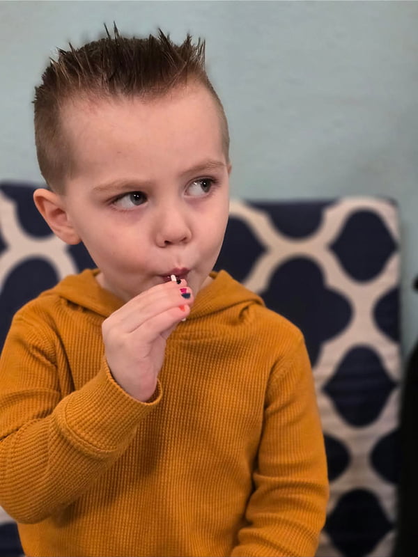 young boy with a sucker after hair cut